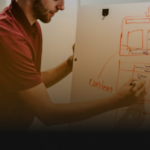 Strategist sketching a customer journey on a whiteboard