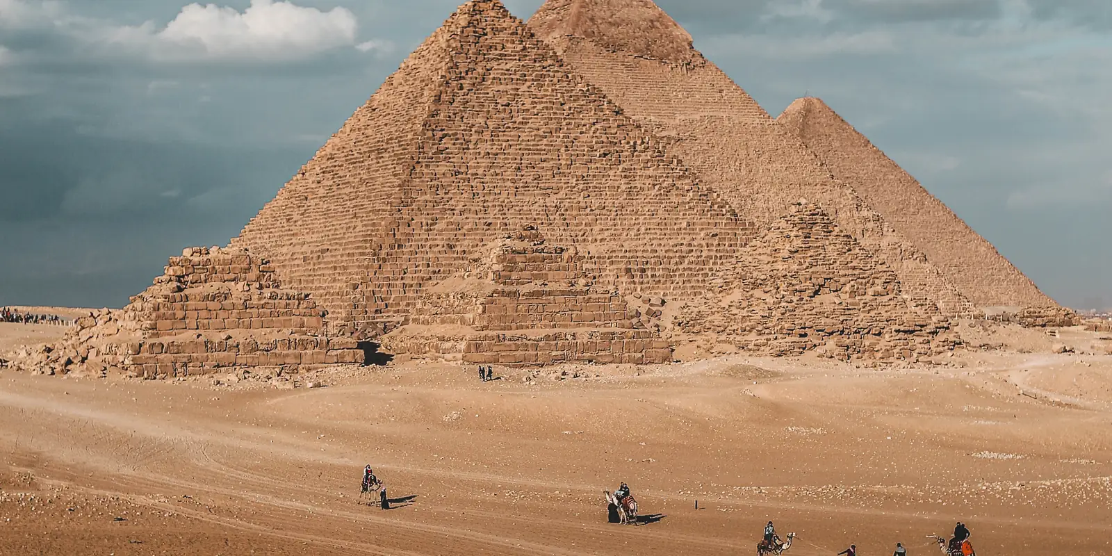 The pyramids of Giza above the desert under a blue sky